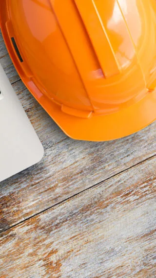 Hard Hat Computer on Table Adobe Stock 485259878
